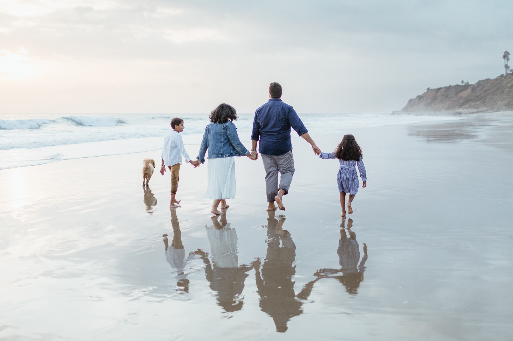 Family walking along the beach at Leo Carrillo State Beach in Malibu California at sunset