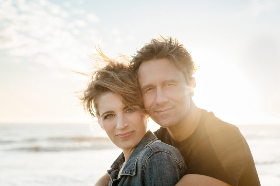 Couple embracing during a sunset couples photography session at Malibu Beach photographed by Erica Montgomery.