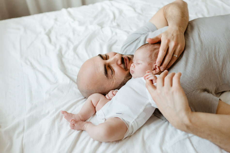Father holding newborn baby during a natural light in-home newborn photography session in Calabasas photographed by Erica Montgomery.