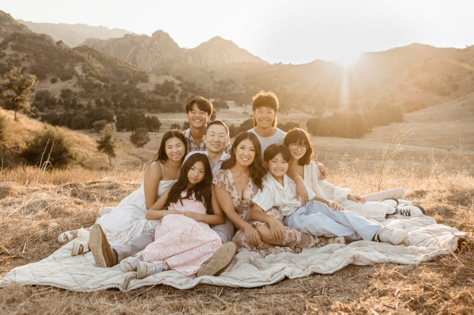 Blended family with many children sitting on a blanket together at sunset during a Calabasas mountain session by Erica Montgomery Photography.