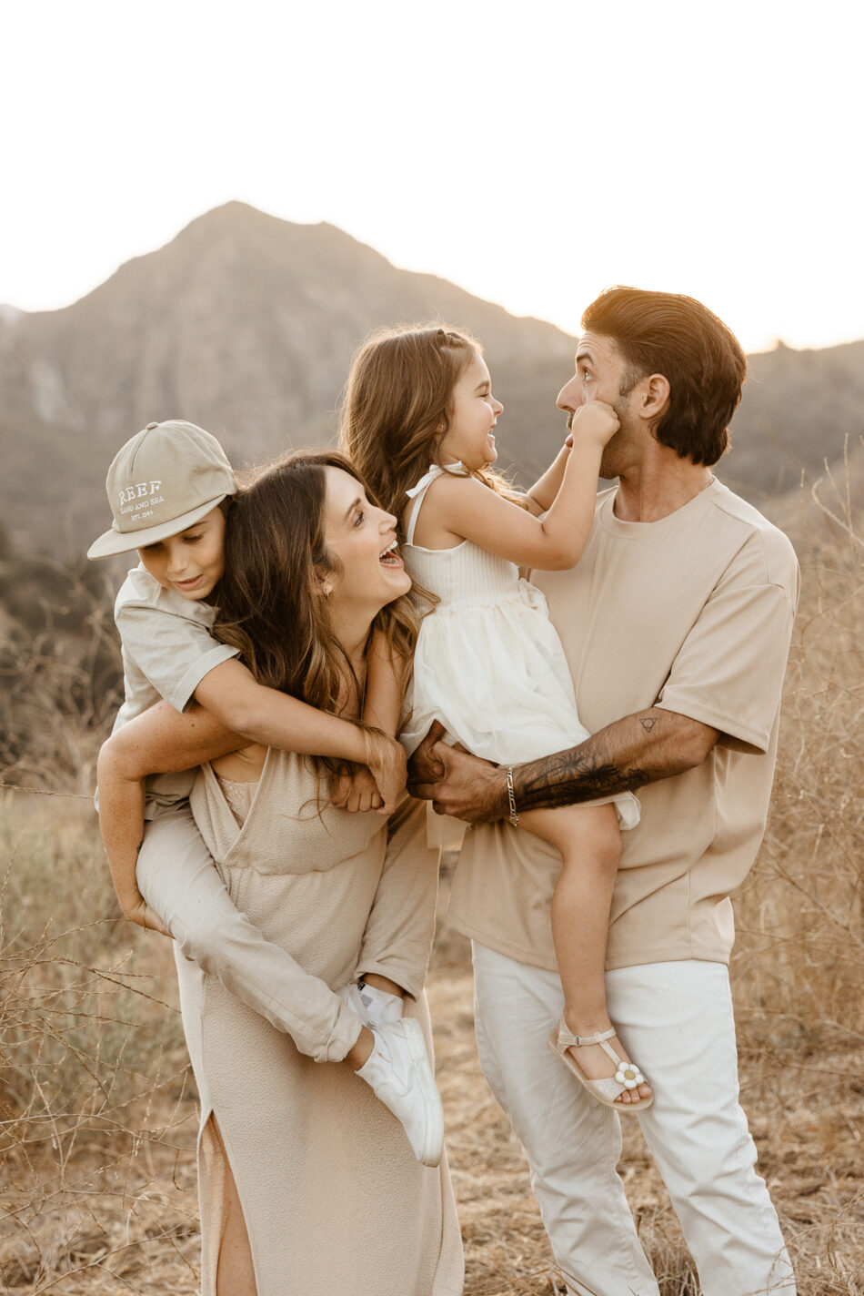Family laughing together during a relaxed outdoor canyon portrait session in Calabasas by Erica Montgomery Photography.