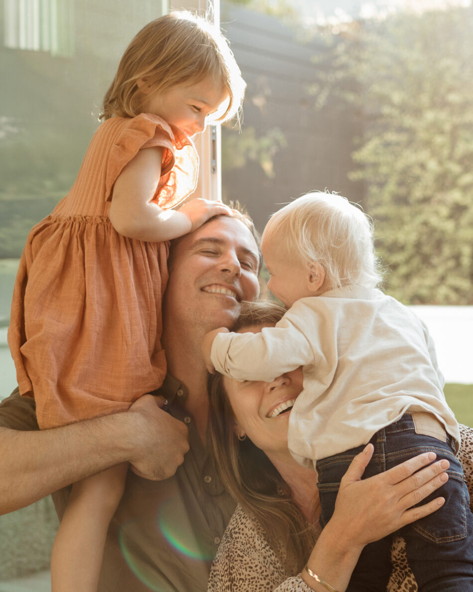 Luminous in-home lifestyle family photoshoot with parents and toddlers playing in warm sunlight by Erica Montgomery Photography.