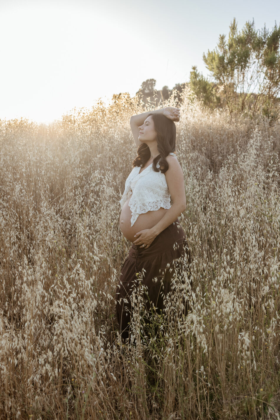 Ethereal outdoor field maternity portraits at Malibu Creek State Park featuring a backlit golden hour solo portrait by Erica Montgomery.