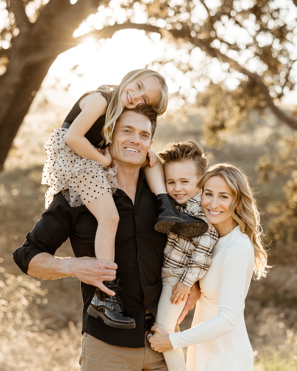 A family smiling together under the oak trees during a warm, natural portrait session at Malibu Creek State Park in Calabasas.